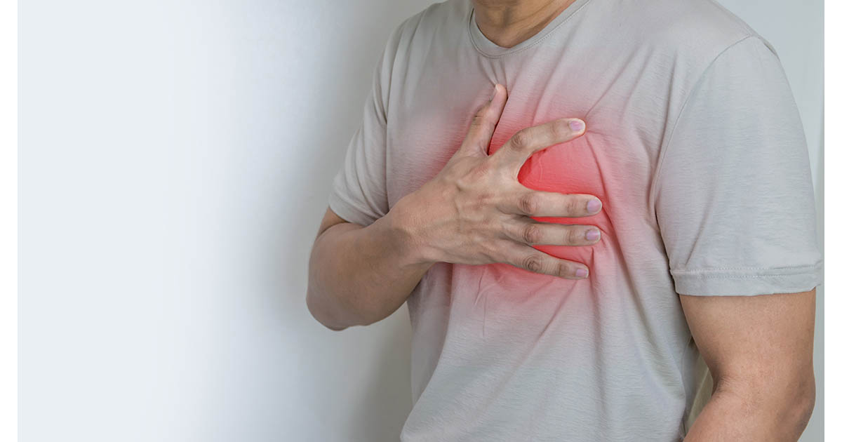 Man pressing both hands against his sternum and chest with a red pain indicator, illustrating the chest wall tenderness and rib pain of costochondritis