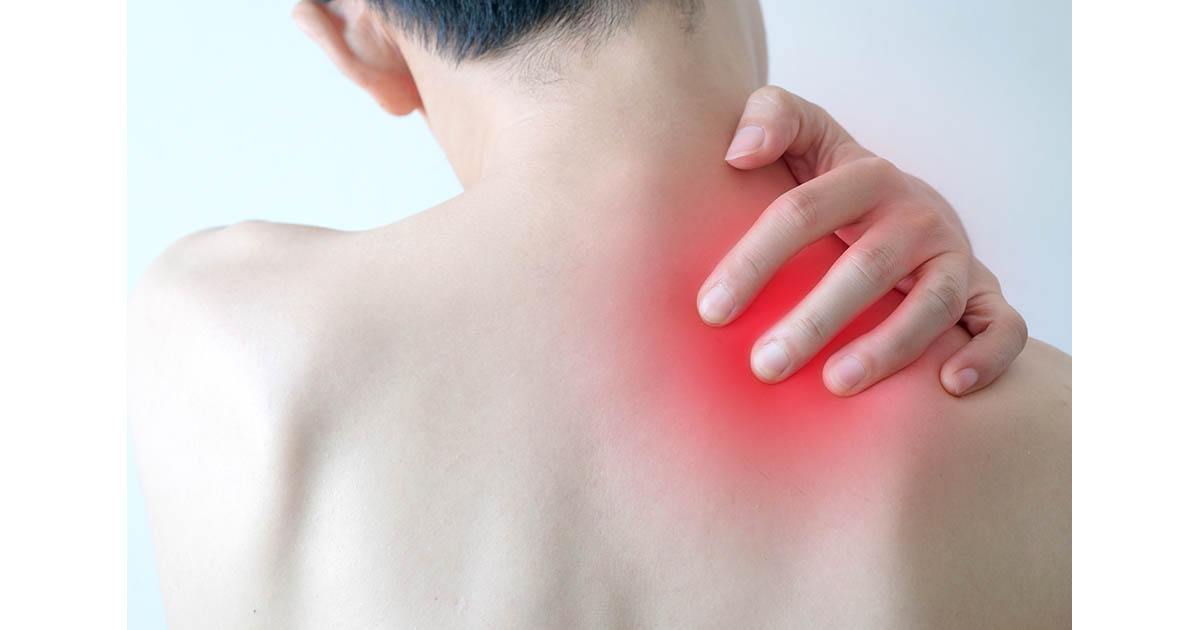 Person pressing fingers into a painful red-highlighted muscle knot at the base of their neck and shoulder