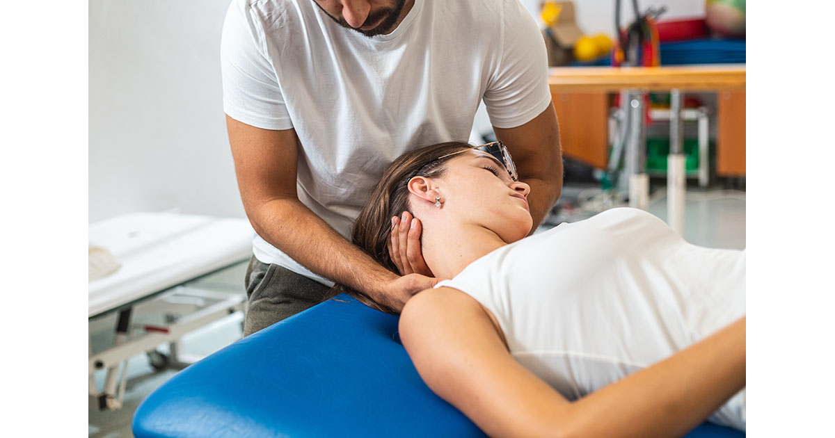 A physiotherapist performing manual cervical traction and neck stretching on a patient in a clinical treatment setting