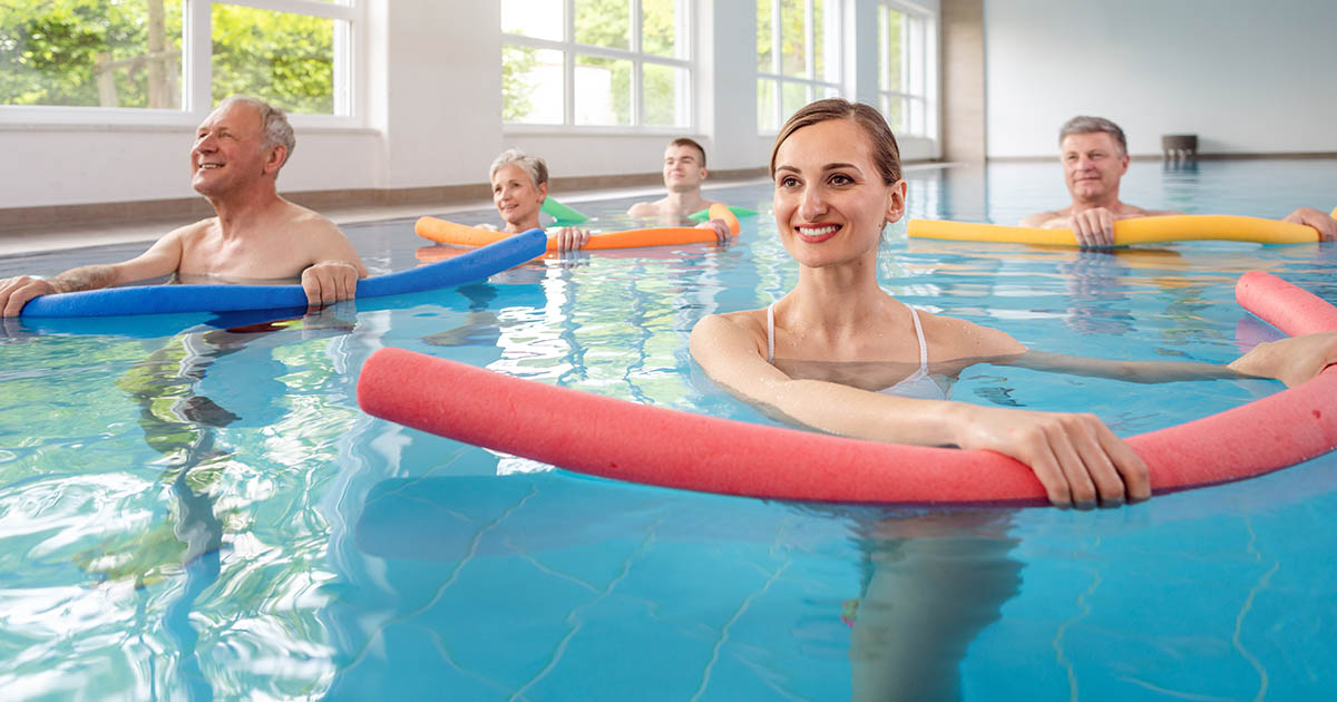 Physical therapy patients performing aquatic exercises in a rehabilitation pool, demonstrating water-based recovery for back pain and spinal conditions