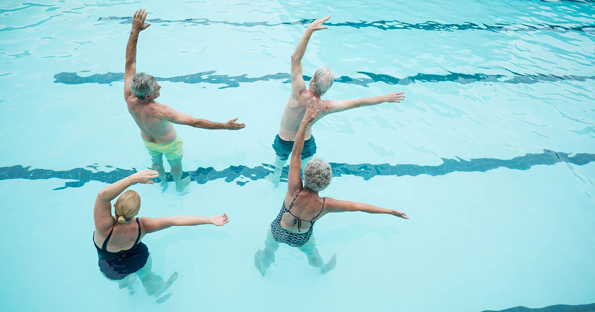Physical therapy patients performing aquatic exercises in a rehabilitation pool, demonstrating water-based recovery for back pain and spinal conditions