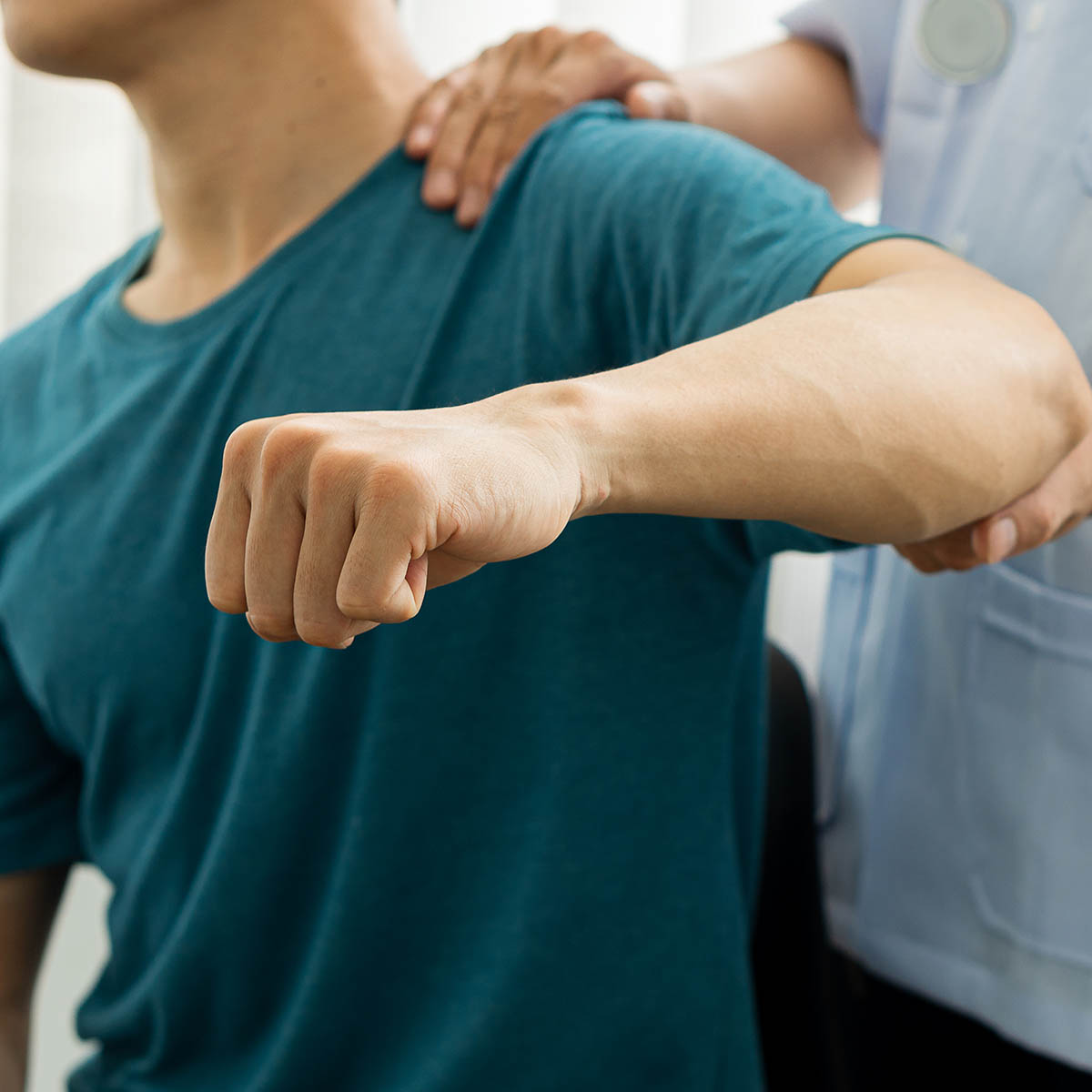 Manual therapist treating a patient's shoulder during a Softwave-style soft-tissue session at Spine & Wellness Center Lakewood Ranch